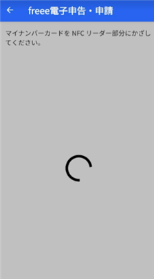 マイナンバーカードをリーダー部分にかざす画面のスクリーンショット